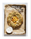 Pistachio-studded peach galette on a baking tray with utensils, recipe on the right.