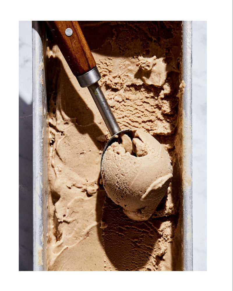 Ice cream scoop with hazelnut milk chocolate ice cream next to a recipe on a white background